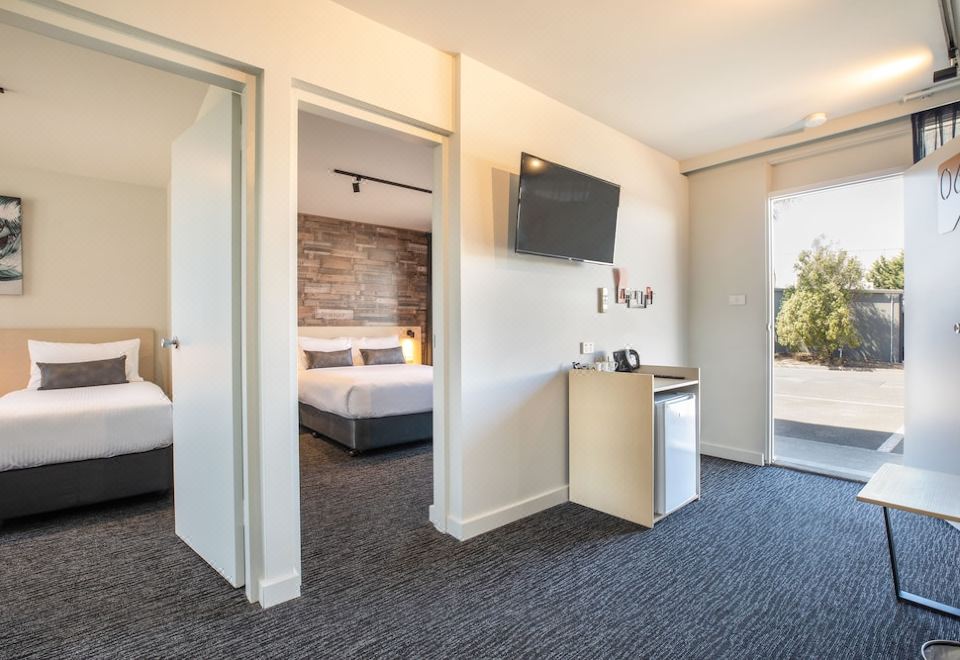 a hotel room with a bed , tv , and other amenities , including a kitchenette and bathroom at Nightcap at Westside Hotel