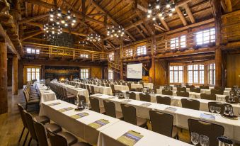 a large , empty conference room with wooden walls and ceiling , rows of chairs set up for a meeting or event at Sunriver Resort