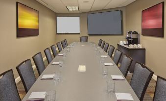 a conference room with a long table , chairs , and a television mounted on the wall at Residence Inn Hartford Avon