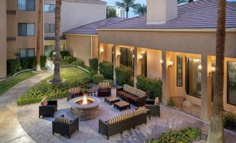 a courtyard with a fire pit surrounded by couches , chairs , and tables , creating a relaxing atmosphere at Courtyard by Marriott Las Vegas Convention Center