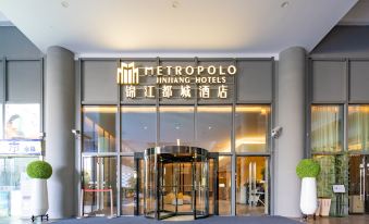 "The entrance to a hotel is adorned with large windows and an illuminated sign displaying the word ""main"" above it" at Metropolo Jinjiang Hotels (Hangzhou East Railway Station)