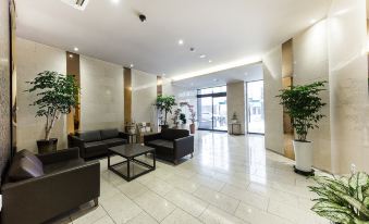 a modern office lobby with various seating options , including couches and chairs , as well as potted plants at The Empress Hotel