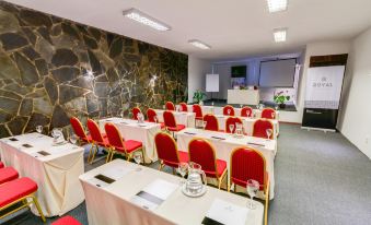 a conference room with rows of chairs arranged in a semicircle , ready for a meeting at Hotel Royal