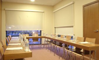 a conference room set up for a meeting , with chairs arranged in rows and a whiteboard on the wall at Posadas de Espana Malaga