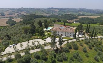 an aerial view of a large villa with a pool , surrounded by lush green hills and trees at Villa le Calvane