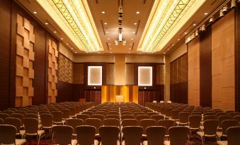 a large conference room with rows of chairs arranged in a semicircle , and a podium at the front at Hotel Metropolitan Nagano