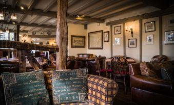 "a cozy room with wooden beams , leather furniture , and a sign reading "" cumbria 's five "" on the wall" at The Wild Boar
