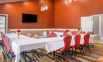 a conference room with a long table , chairs , and a television mounted on the wall at Quality Inn