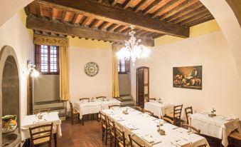 a large dining room with wooden tables and chairs arranged for a group of people at Palazzo Leopoldo Dimora Storica & Spa