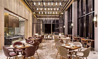 a modern restaurant with wooden tables and chairs , a large window , and a black ceiling at Dusitd2 Khao Yai