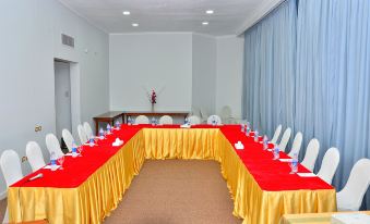 a conference room set up for a meeting , with multiple tables and chairs arranged in a semicircle at Aracan Pyramids Hotel