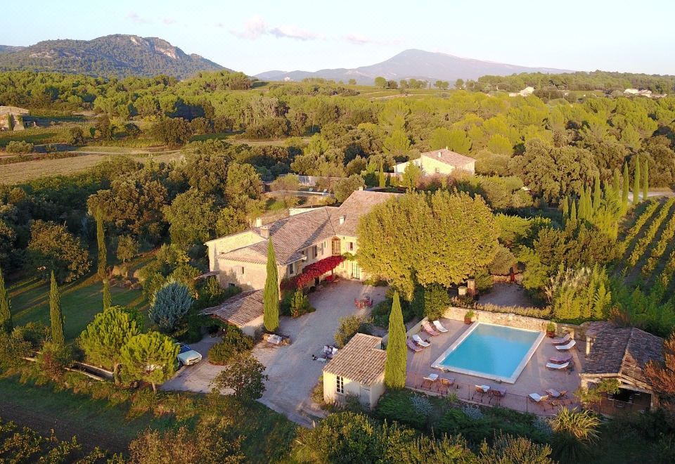 an aerial view of a large villa surrounded by trees , with a swimming pool in the foreground at Le Clos Saint Saourde