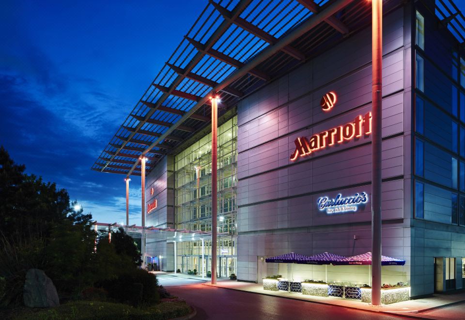"a large building with a red and white sign that says "" marriott "" is lit up at night" at London Heathrow Marriott Hotel
