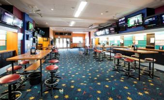 a large , well - lit sports bar with multiple tvs and multiple couches , as well as several tables and chairs for patrons to enjoy their at Nightcap at the Charles Hotel