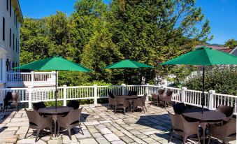 a patio with green umbrellas , chairs , and tables set up for outdoor dining or relaxation at The Equinox