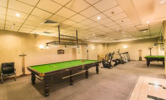 a pool table is in the middle of a room with exercise equipment on either side at Lanzhou Feitian Hotel (Lanzhou University Subway Station)