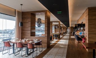 a modern dining room with wooden walls , a dining table , chairs , and a long hallway at Octant Ponta Delgada