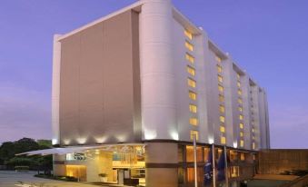 a large white building with a parking lot in front of it , illuminated at night at Four Points by Sheraton Ahmedabad
