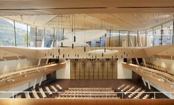 a large , modern auditorium with multiple rows of seats and a stage at the front at Radisson Blu Hotel Reussen Andermatt