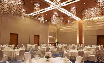 a large banquet hall with multiple round tables and chairs , all set for a formal dinner at Courtyard by Marriott Mumbai International Airport