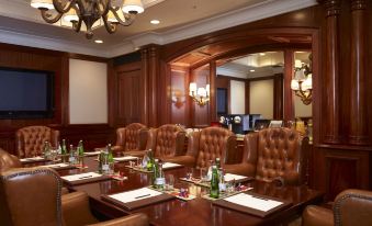 a conference room with leather chairs arranged around a wooden table , creating a warm and inviting atmosphere at Palazzo Hotel