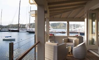 a boat docked at a marina , with a couch and chairs on the deck overlooking the water at South Point Antigua