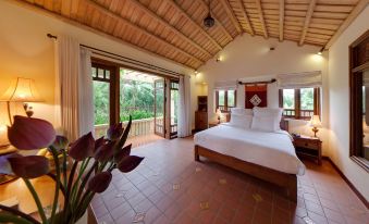 a spacious bedroom with a large bed , hardwood floors , and a television mounted on the wall at Emeralda Resort Ninh Binh