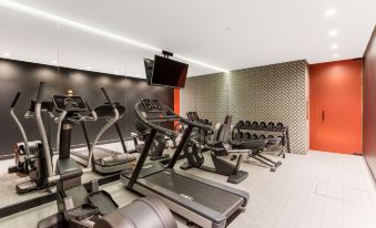 a gym with various exercise equipment , including treadmills and weightlifting machines , in a spacious room at Room Mate Giulia