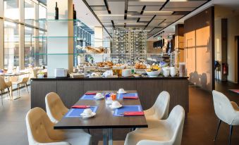 a restaurant with a dining area filled with tables and chairs , where several people are enjoying their meals at Novotel Lugano Paradiso