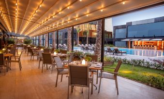 an outdoor dining area with several tables and chairs arranged for guests to enjoy a meal at Burgu Arjaan by Rotana