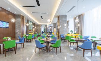 The restaurant features large tables and chairs in the center, as well as additional seating areas at Hampton by Hilton Ji'an