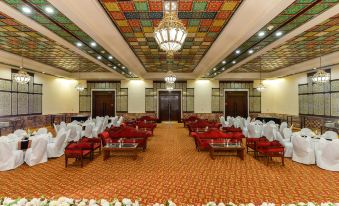 a large , empty banquet hall with multiple rows of tables and chairs set up for a formal event at Faisalabad Serena Hotel