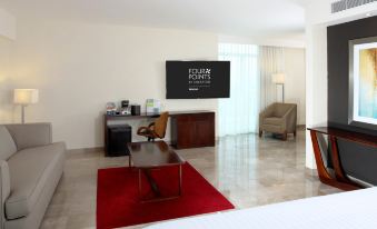a hotel room with a bed , desk , chair , and television on the wall above the bed at Four Points by Sheraton Veracruz