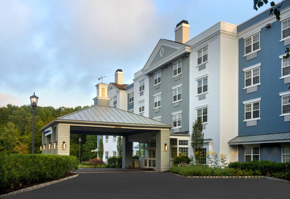 an exterior view of a hotel building , with the hotel 's entrance visible through an open gate at Delta Hotels Basking Ridge