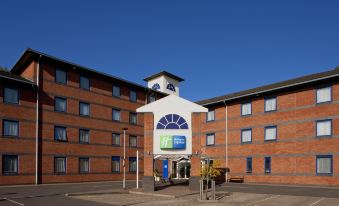 a brick building with a clock tower , located in a city setting under a clear blue sky at Holiday Inn Express Droitwich Spa