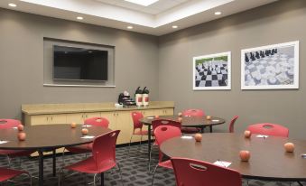 a dining room with a table and chairs arranged for a group of people to enjoy a meal together at TownePlace Suites by Marriott Champaign