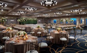 a large banquet hall with multiple round tables and chairs set up for a formal event , possibly a wedding reception at Omni Barton Creek Resort and Spa Austin