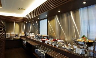 a dining area with a long wooden table filled with various food items and utensils at Hamamatsu Hotel
