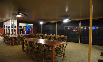 a large dining room with a long wooden table and several chairs arranged around it at Peppermill Inn Motel