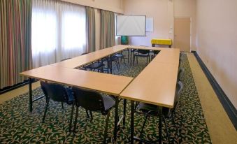 a conference room with several tables and chairs arranged for a meeting or training session at Red Lion Inn and Suites Victoria