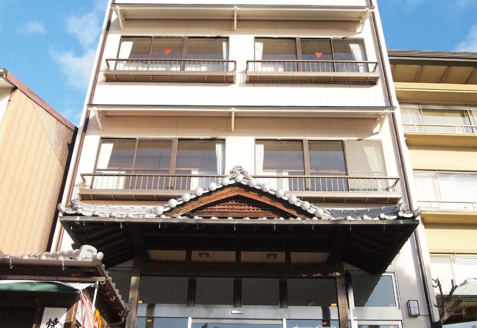 a building with multiple floors and balconies , possibly a hotel or office building , located in a city street at Sakuraya
