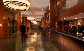 The main room of this hotel features a large lobby with an illuminated ceiling and tiled floors at Royal Garden Hotel