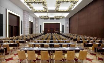 a large conference room with rows of chairs arranged in a semicircle , and a podium at the front at The Romanos, a Luxury Collection Resort, Costa Navarino