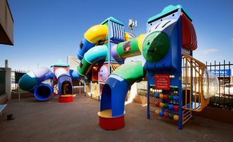 a colorful playground with various play structures , such as slides and swings , for children to enjoy at Wilsonton Hotel