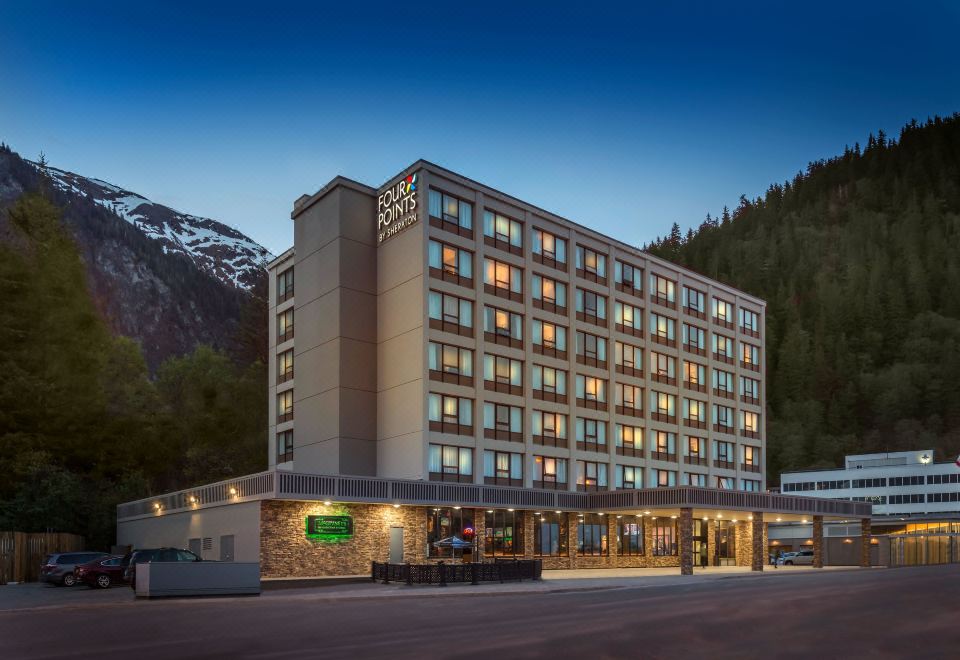 "a large hotel building with many windows and a sign that says "" holiday inn "" in the evening" at Four Points by Sheraton Juneau