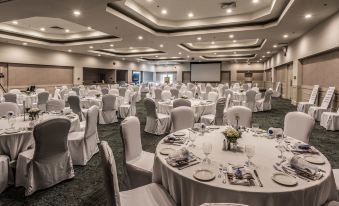 a large banquet hall filled with tables and chairs , ready for a formal event or a wedding reception at Georgian Bay Hotel, Trademark Collection by Wyndham