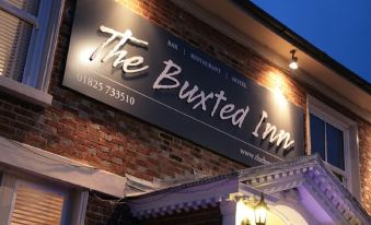 "a building with a sign that reads "" the buxted inn "" prominently displayed on the front" at The Buxted Inn
