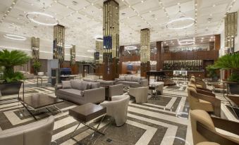 a luxurious hotel lobby with gray couches , chairs , and tables arranged in a lounge - like setting at DoubleTree by Hilton Istanbul-Avcilar