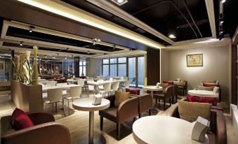 a modern restaurant with various dining tables and chairs , as well as a bar area at Micasa Hotel