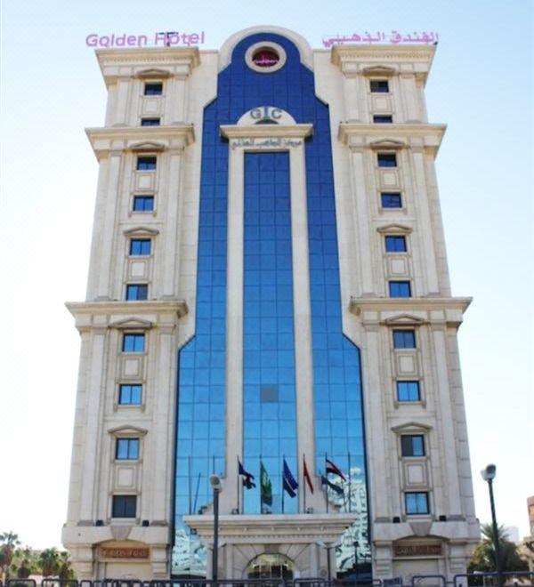 a large , modern building with a blue and white facade is shown from a low angle at Golden Hotel